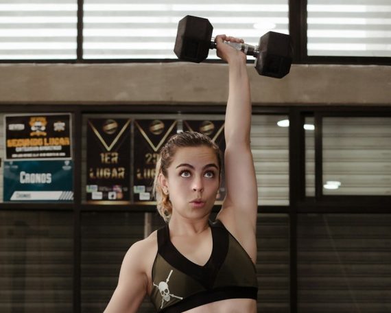 woman exercising with dumbbell inside gym